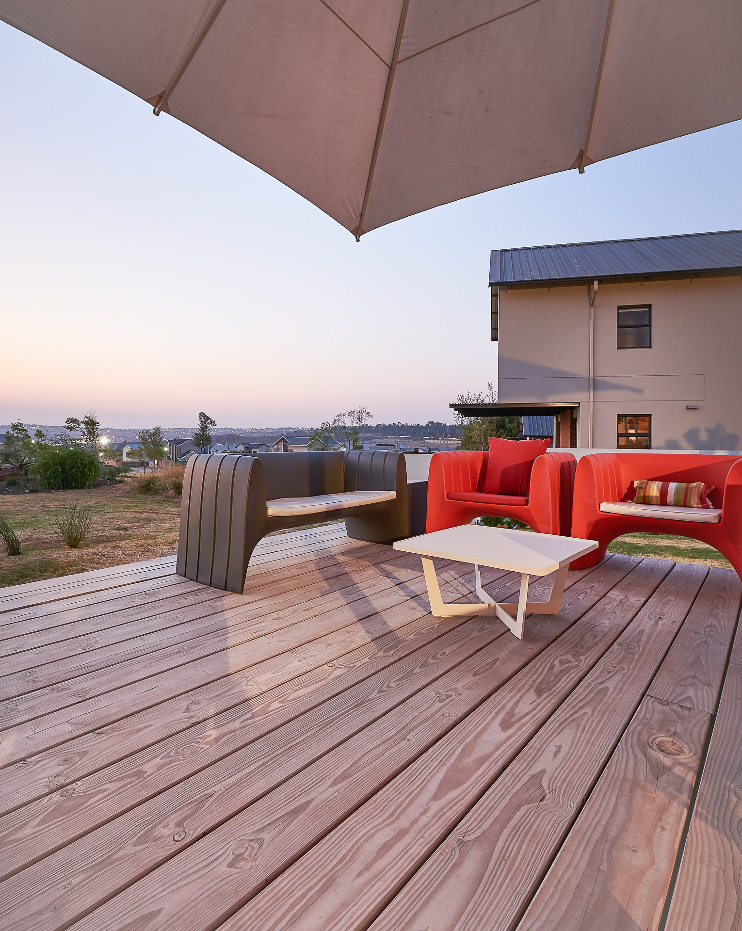 Open terrace with wooden floorboards, outdoor furniture and parasol