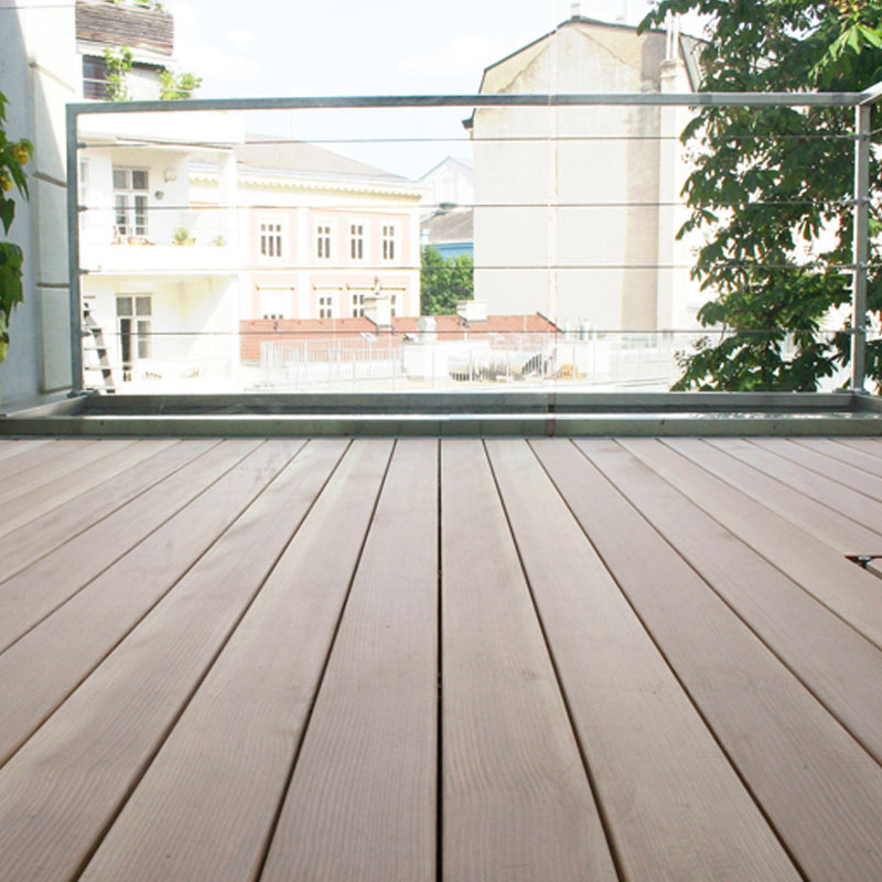 Vue d'une terrasse de toit avec des planches de terrasse sobres avec des cernes d'arbres debout